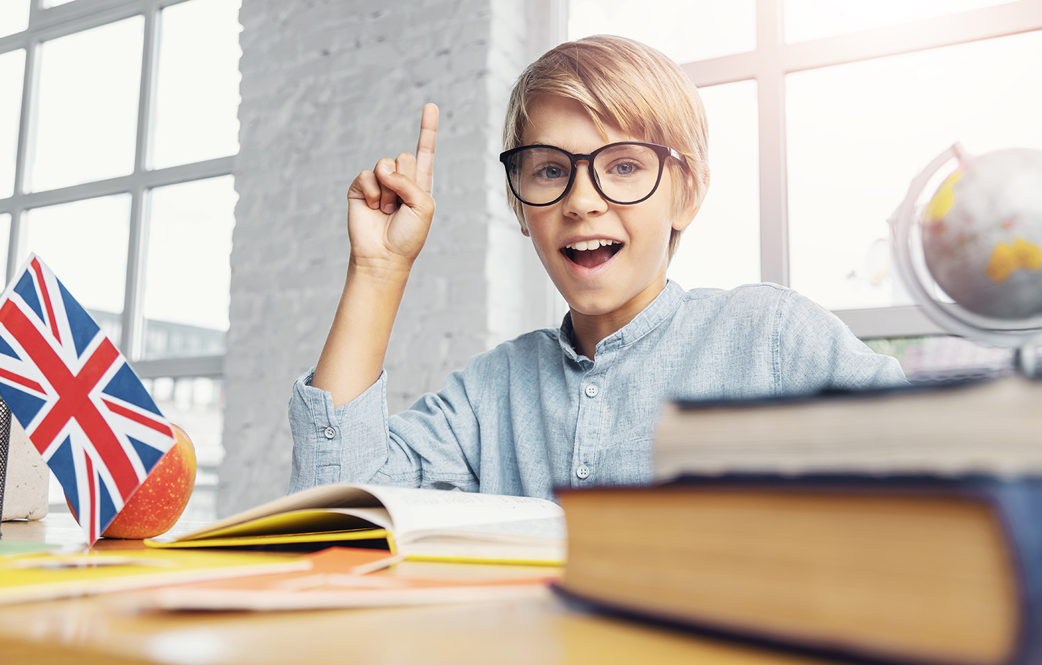 young_smart_boy_holding_finger_up_classroom_having_idea_learning.jpg