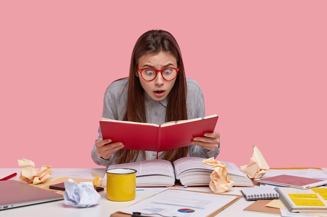 shot-stupefied-young-female-worker-stares-opened-notepad-studies-list-coming-weekend-has-much-work-mess-workplace_273609-24418.jpg