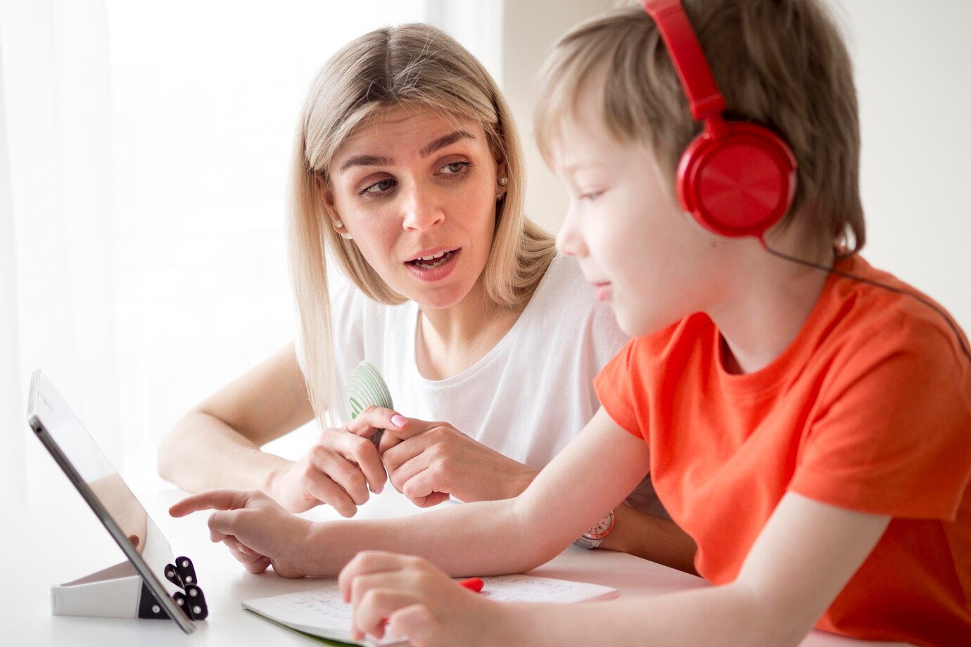 boy_wearing_headphones_and_writes_next_to_his_mother_23_2148552334.jpg