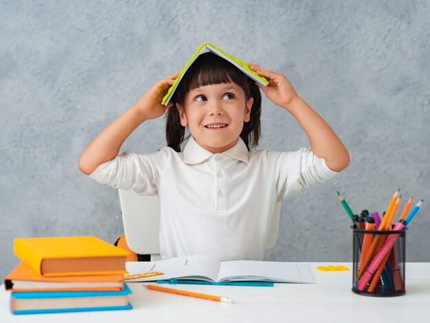 back_to_school_cute_child_schoolgirl_sitting_at_a_desk_in_a_room.jpg