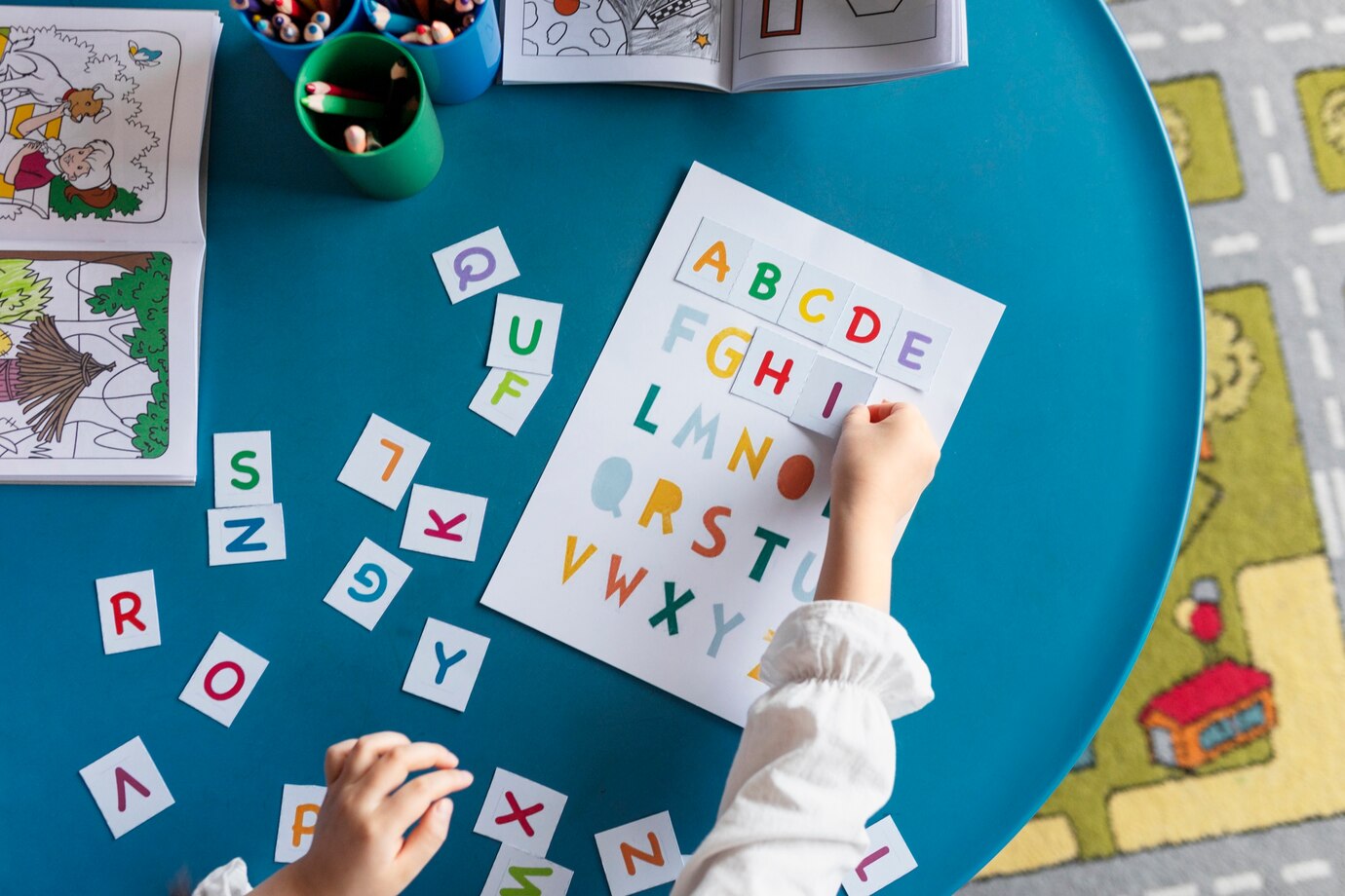 top-view-kid-learning-letters-at-kindergarten_23-2149355200.jpg